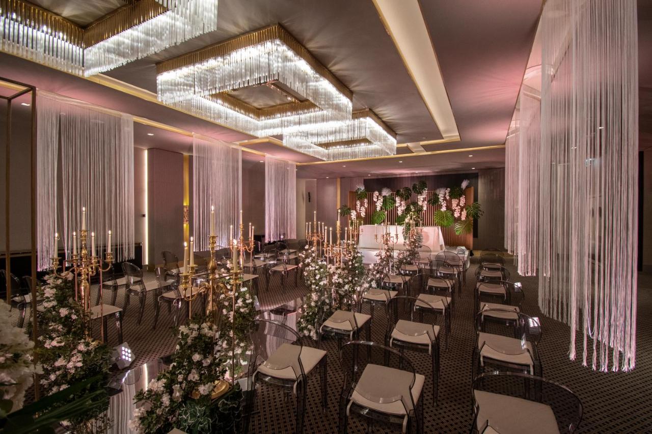 Epic Sana Marques Hotel Lissabon Exterior foto The photo depicts an elegantly decorated indoor event space, likely set up for a special occasion like a wedding or formal gathering. The room features stylish chandeliers with crystal elements that provide soft lighting. There are multiple tables ar