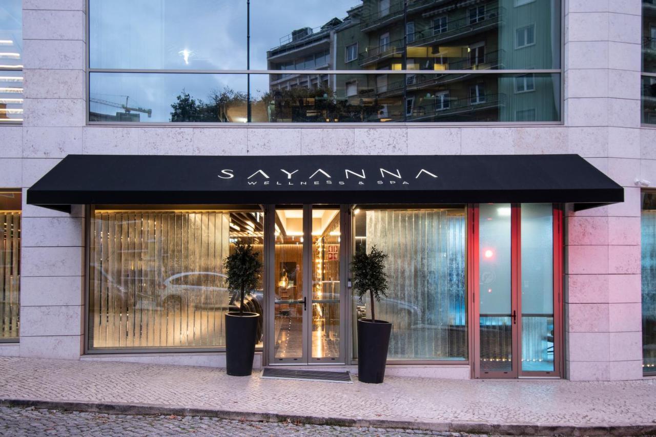 Epic Sana Marques Hotel Lissabon Exterior foto The photo shows the entrance of a building with a modern design. A black awning with the name "SAYANNA" is prominently displayed above the door. The entrance features glass doors and large windows, allowing visibility into the interior. There are pot